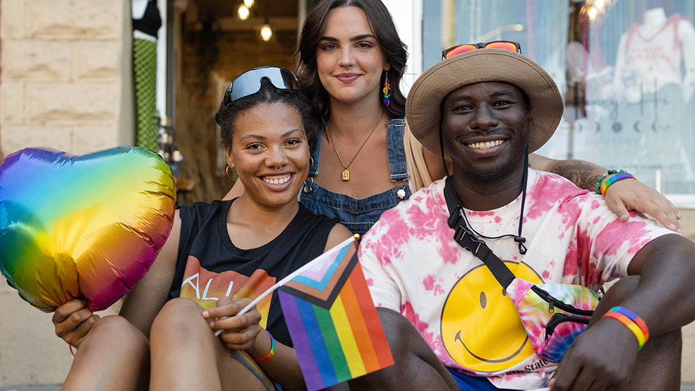 Happy crowd at Capital Pride Parade waving rainbow flags