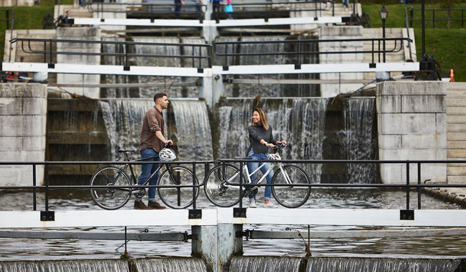 Cyclist crossing the Rideau Canal locks in fall