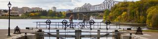 Cyclist crossing the Rideau Canal locks in fall